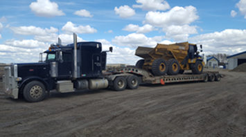 Lowboy hauling rock truck