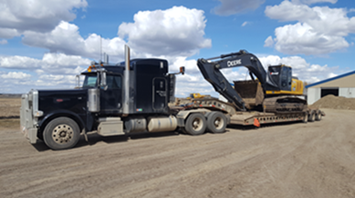 Lowboy hauling track hoe